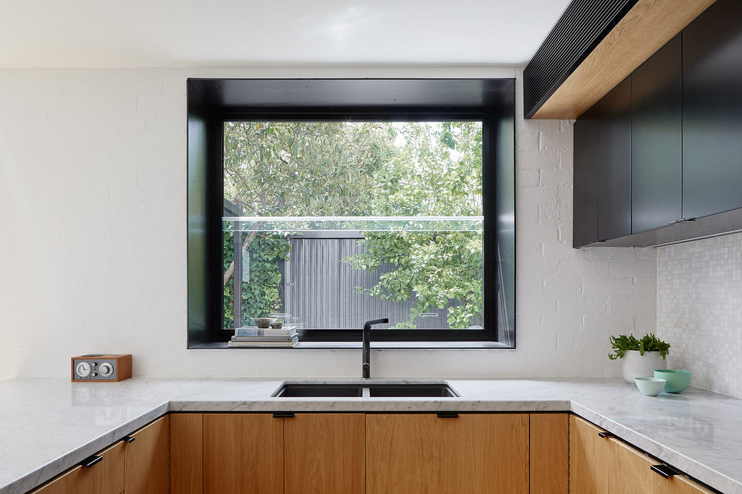 Modern kitchen with wooden cabinets and a large window.
