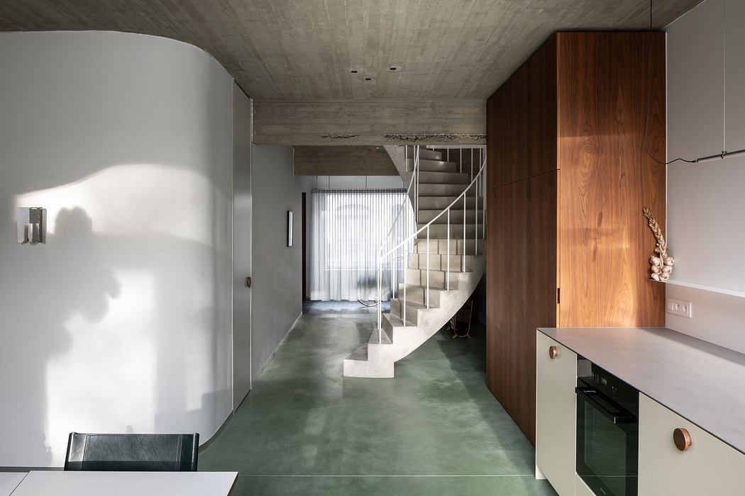 Modern interior with concrete ceiling, wooden accents, and a floating staircase.