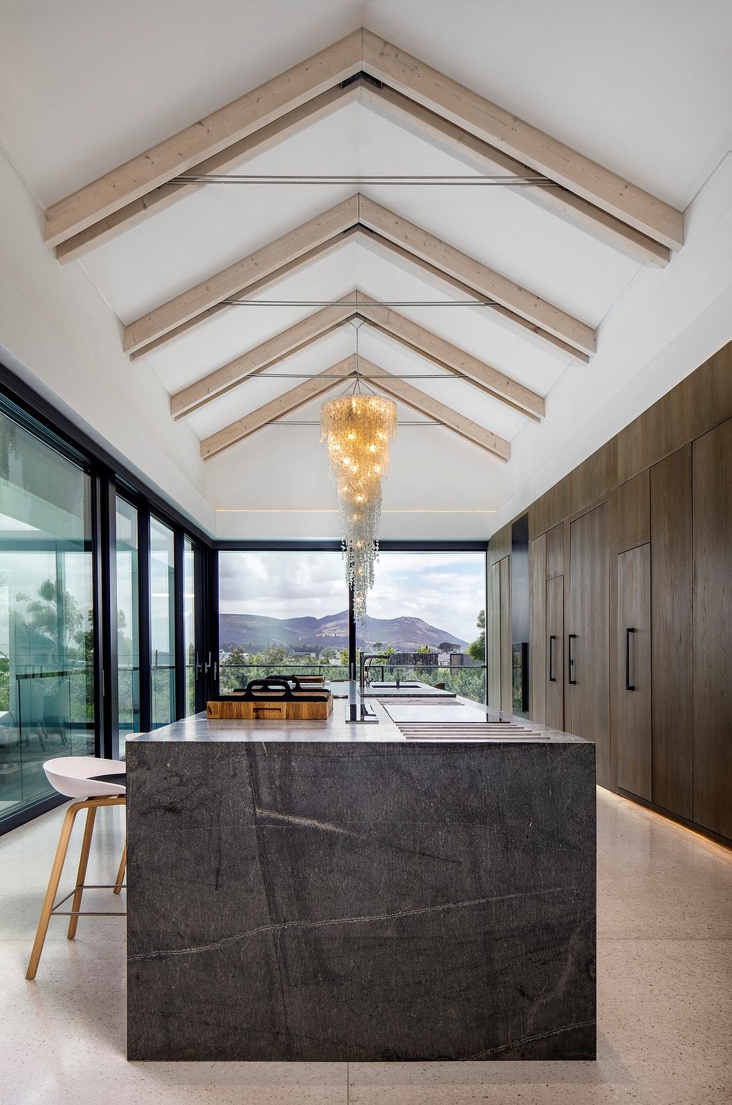 Modern kitchen with vaulted ceiling, pendant light, and large island.