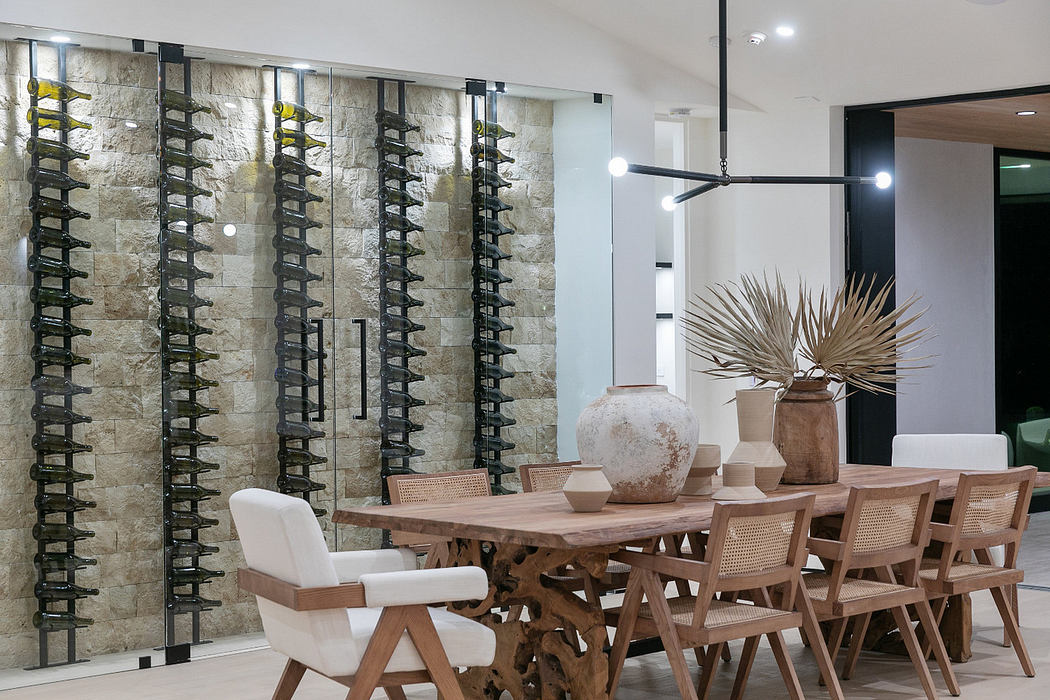 Modern dining room with wooden table, chairs, and wine storage wall.