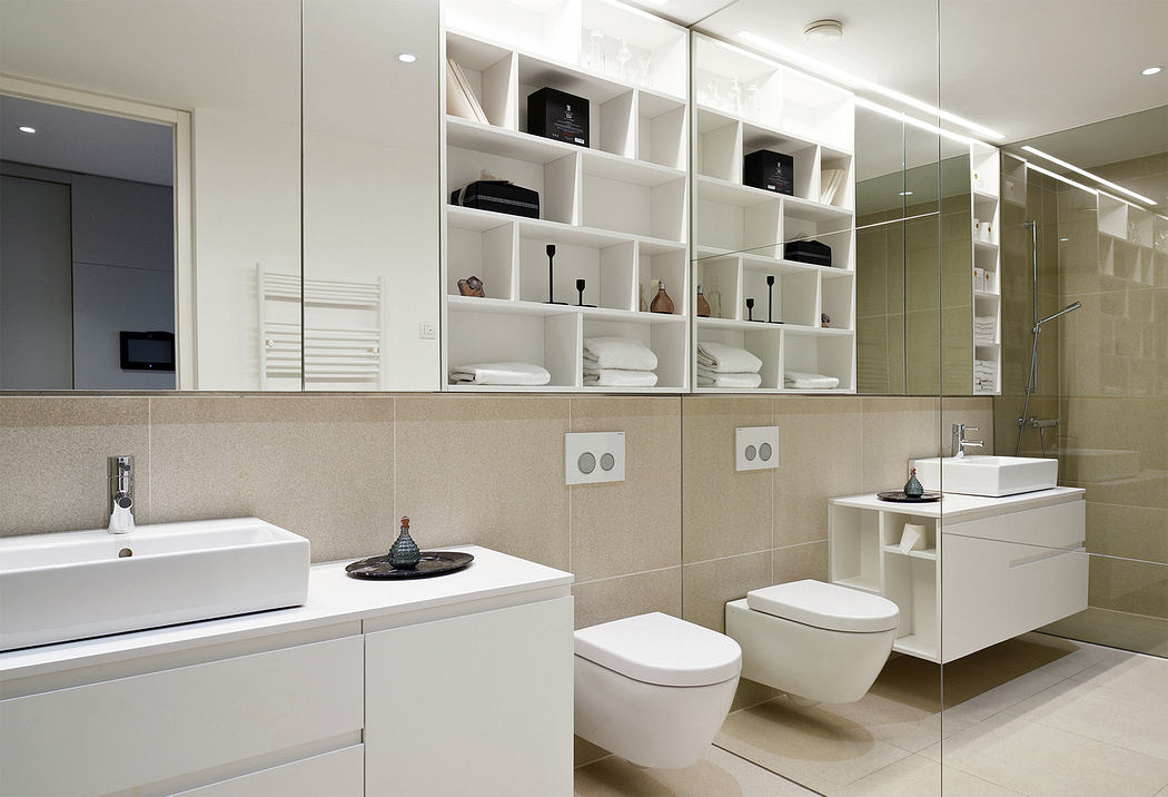 Modern bathroom interior with white fixtures and shelving.