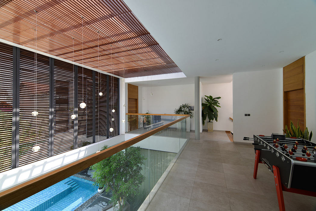 Modern interior with glass balcony overlooking a pool, wooden accents, and a foos