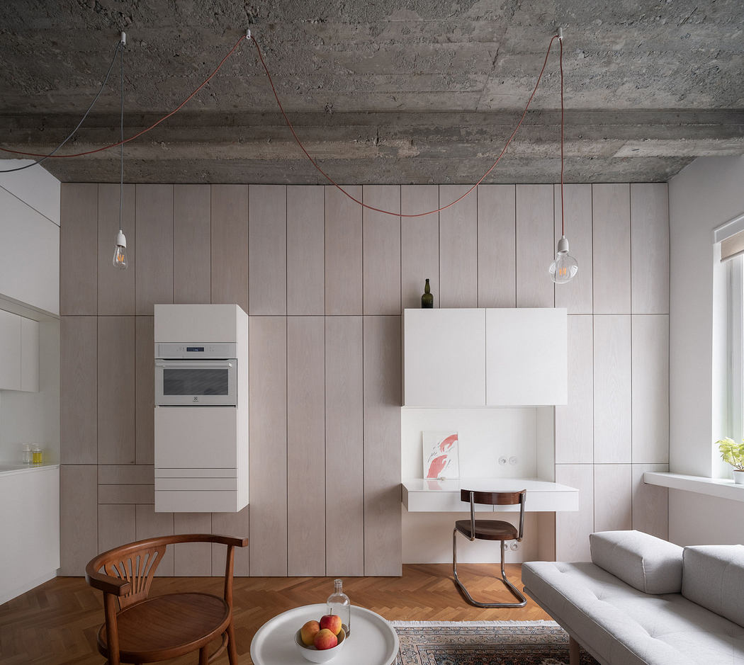 Modern minimalist kitchen with exposed concrete ceiling and pendant lights.