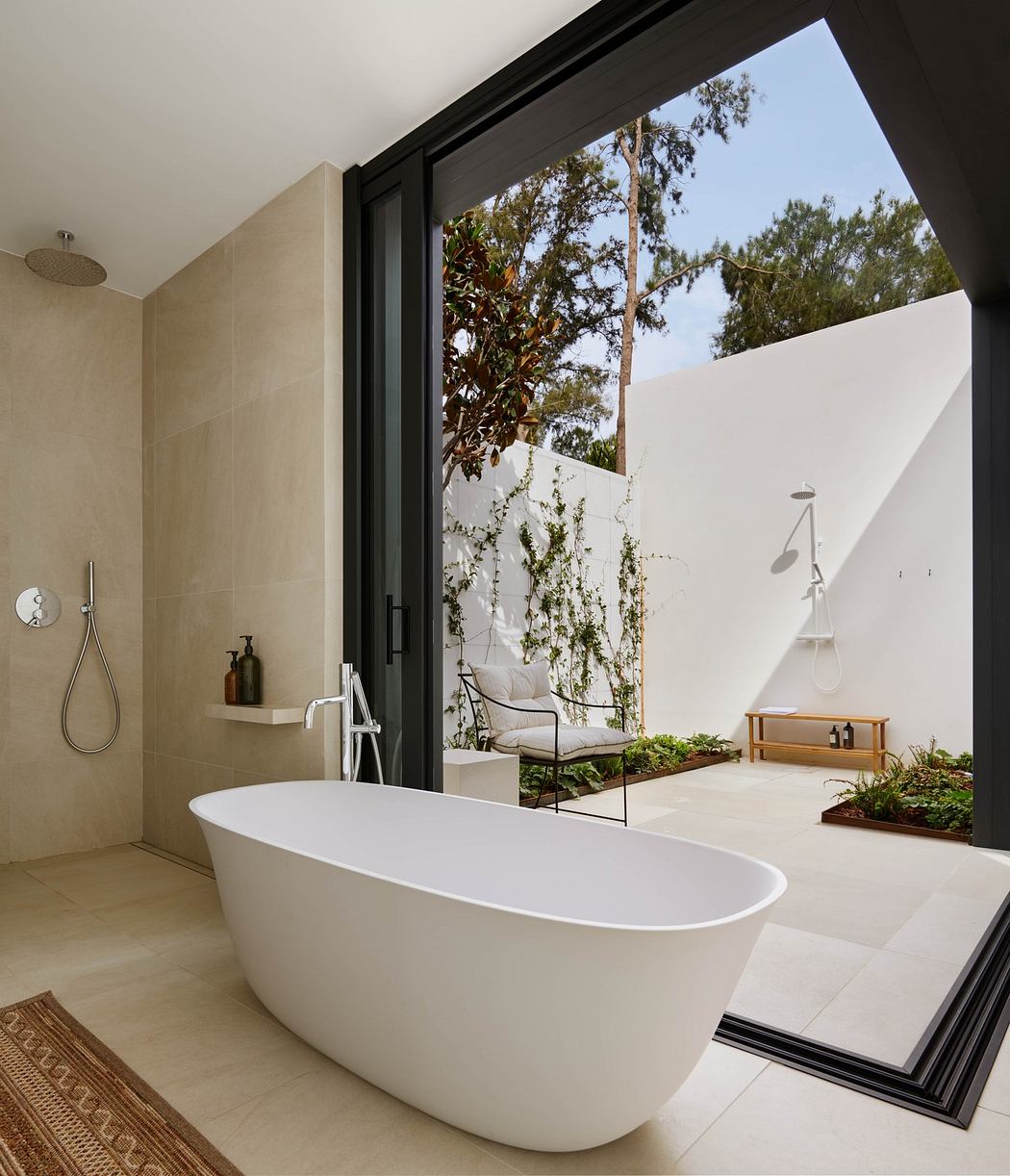 Modern bathroom with standalone tub, open shower, and view of private patio.