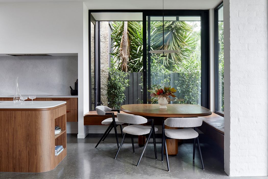 Modern kitchen with wooden island and dining area overlooking a garden.