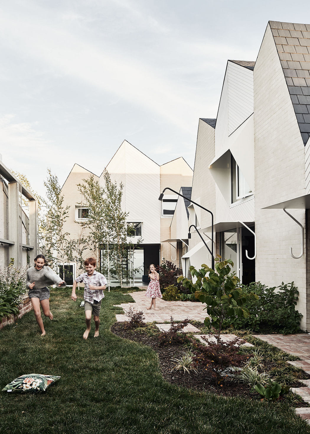 Modern homes with geometric design and children playing in the yard.
