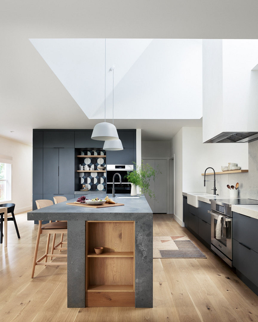 Modern kitchen with clean lines, a central island, and contrasting dark cabinets.