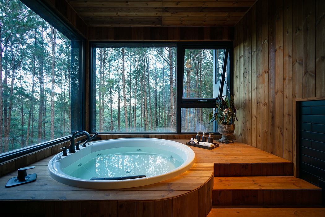 Wooden bathroom with circular tub and forest view through large window.