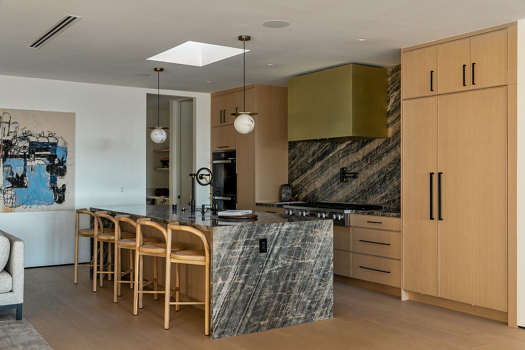 Modern kitchen interior with wooden cabinets and marble island.
