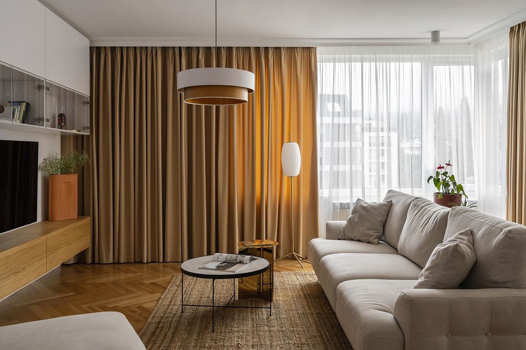 Modern living room with beige sofa, wooden floors, and draped curtains.