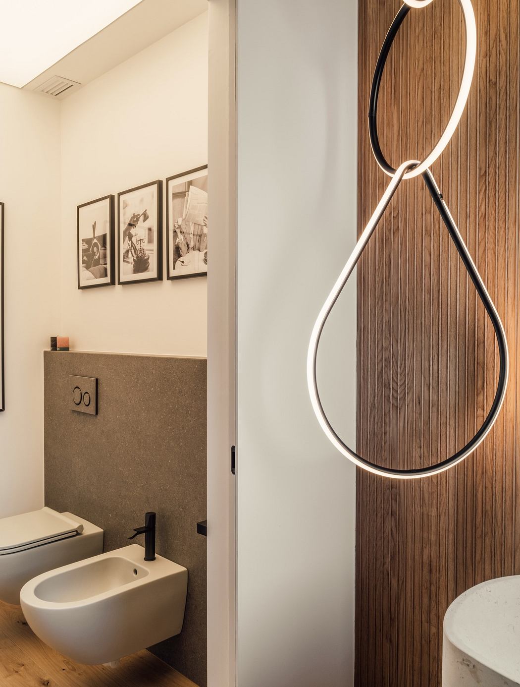 Modern bathroom with unique lighting, wooden accents, and minimalist fixtures.