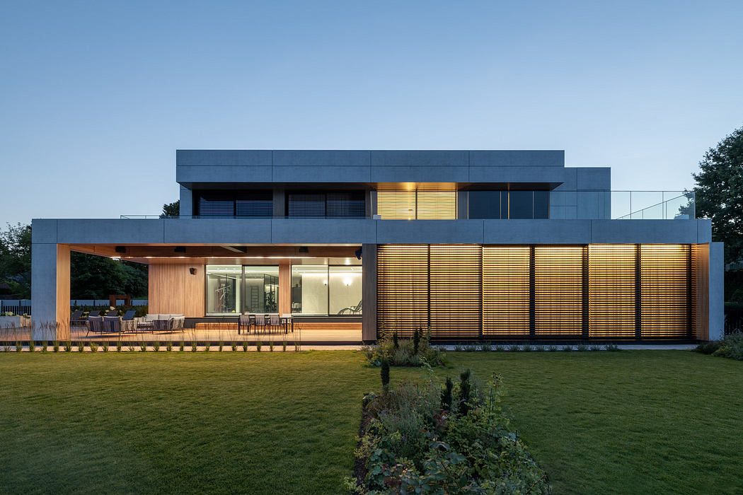 Modern two-story house with large windows and exterior lighting at dusk.