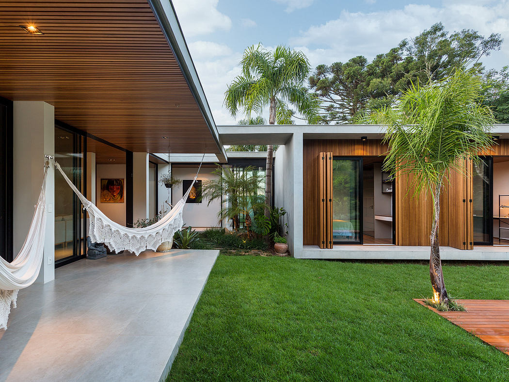Modern home exterior with hammock, lawn, and wooden accents.