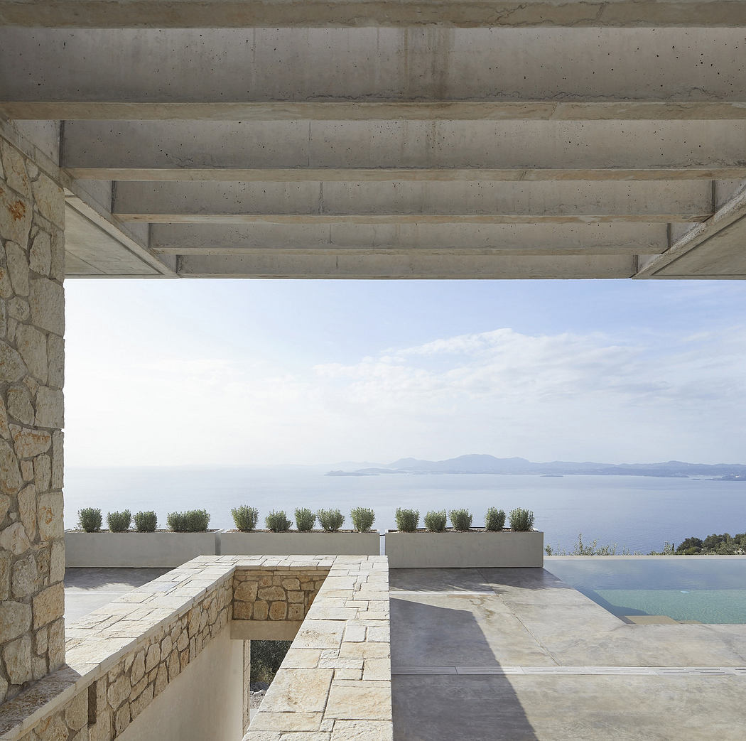 Modern terrace with stone walls, concrete ceiling, and ocean view.