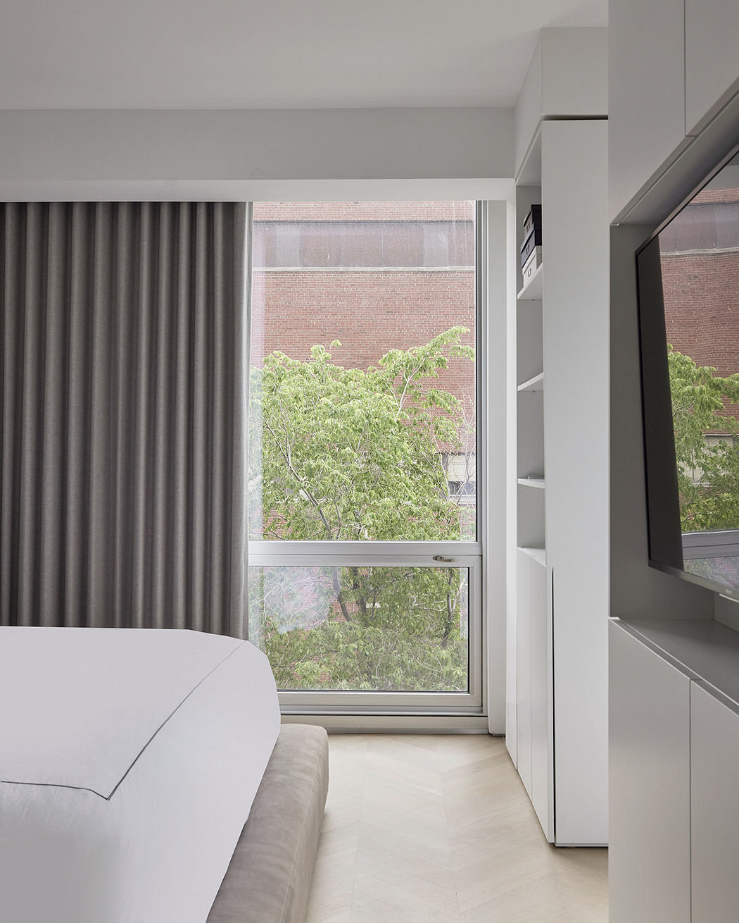 Modern room with large window, grey curtains, and minimalist furnishings.