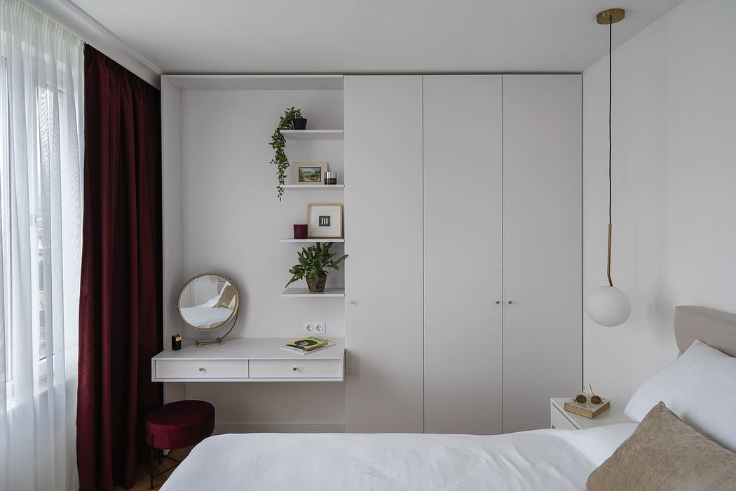 Modern minimalist bedroom with built-in white wardrobe and shelves.