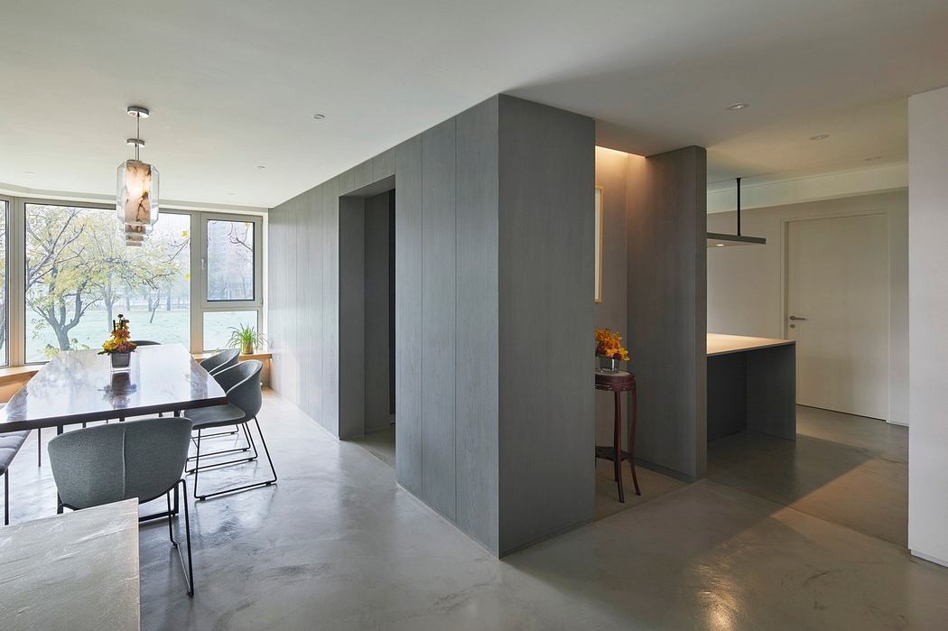 Modern dining room with a minimalist design, grey tones, and ample natural light.