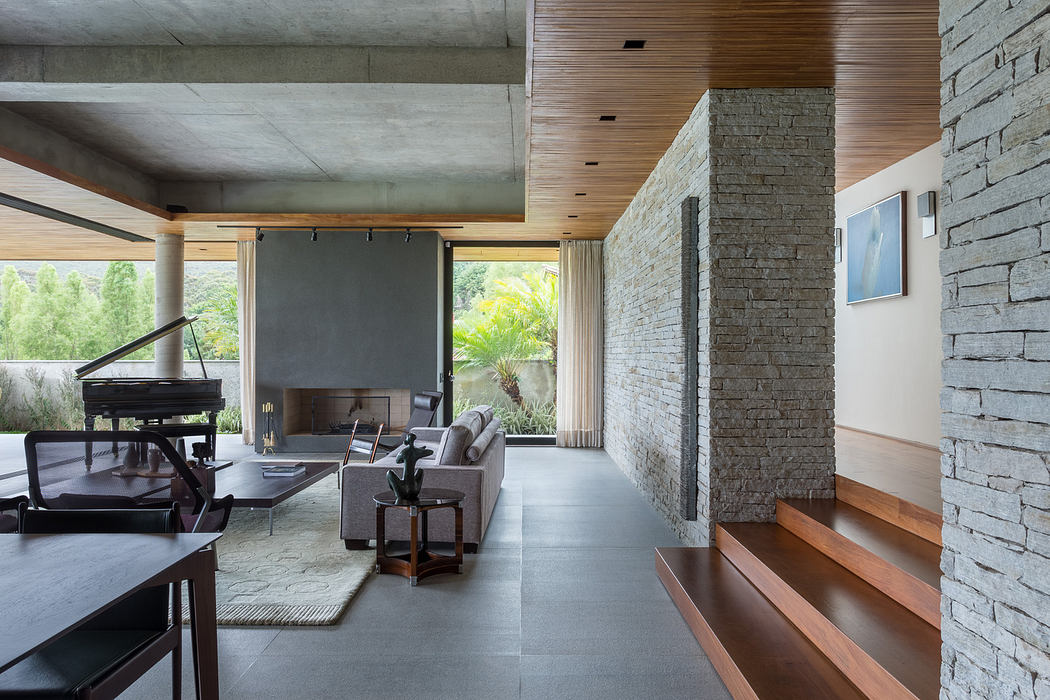 Modern living room with concrete, wood accents, and grand piano.