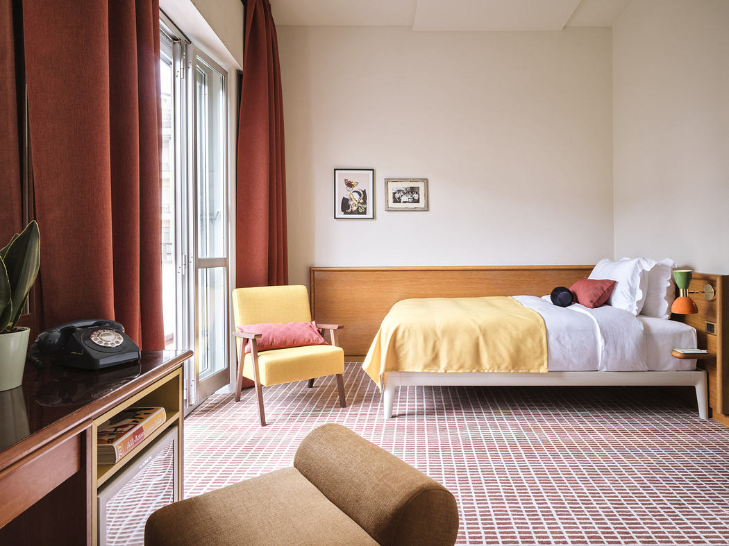 Modern bedroom with a yellow bed, patterned floor, and vintage furniture.