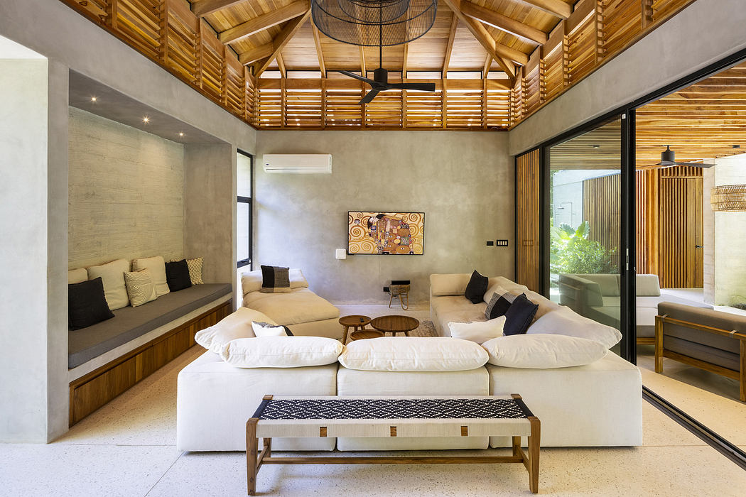 Modern living room with a white couch, wooden ceiling, and concrete walls.