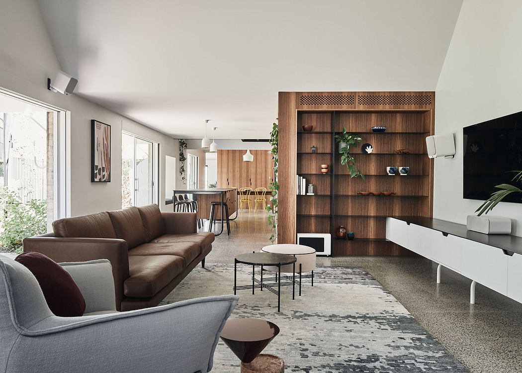 Modern living room with sleek furniture and a wooden partition.