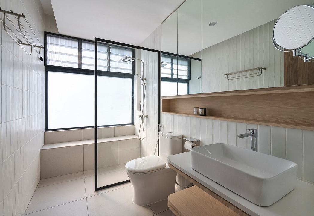 Modern bathroom with glass shower, white tiles, wooden accents, and a large mirror