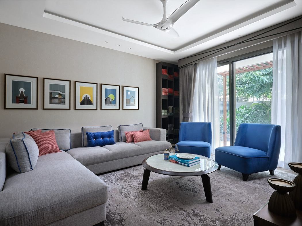 Modern living room with grey sofa, blue armchairs, and art on walls