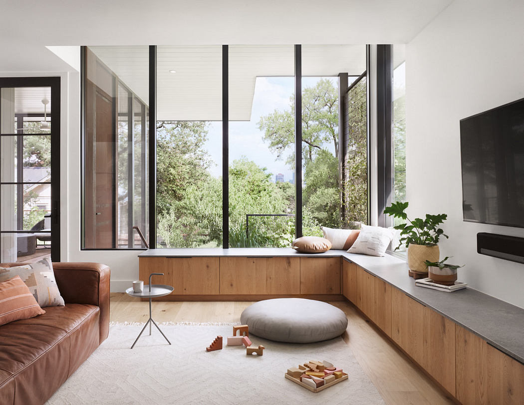 Modern living room with large windows, wooden accents, and minimalist furniture.