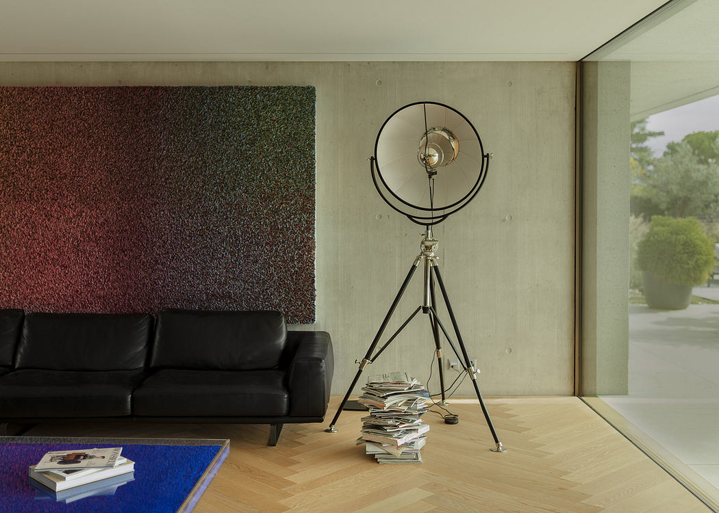 Modern living room with a black sofa, tri-pod lamp, and textured wall