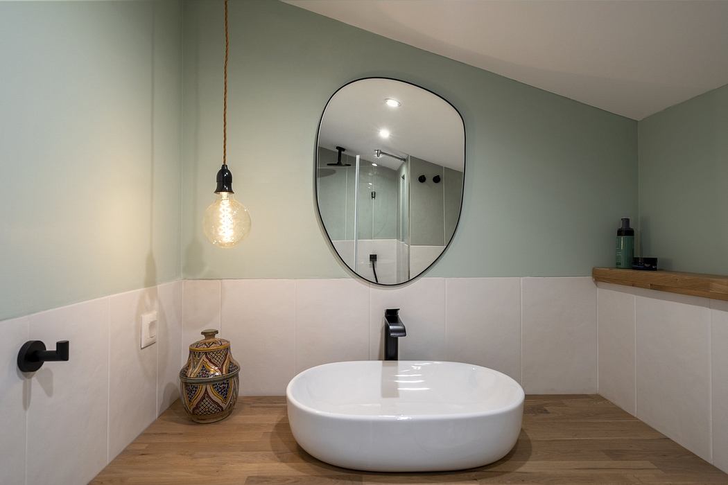 Modern bathroom with a round mirror and vessel sink.