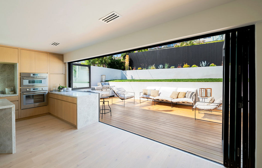 Modern open-plan living room with kitchen and seamless indoor-outdoor flow.