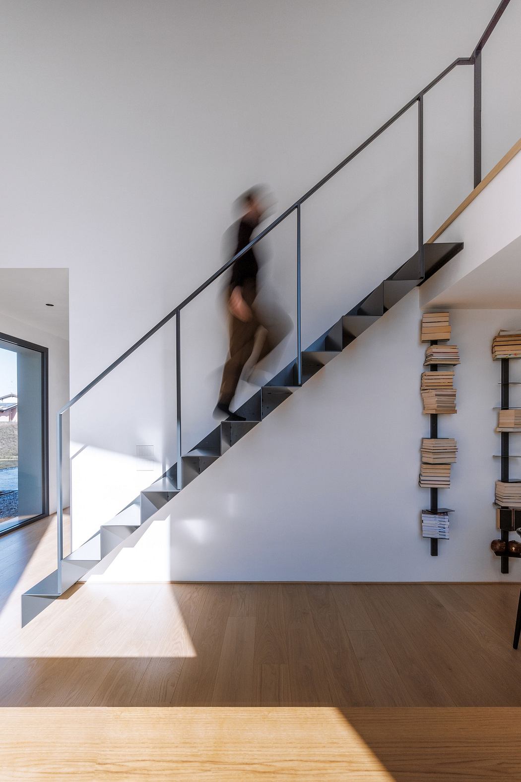 Modern staircase with a person ascending and wooden floor details.