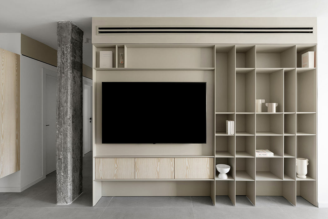 Minimalist living room with built-in TV unit and shelving.