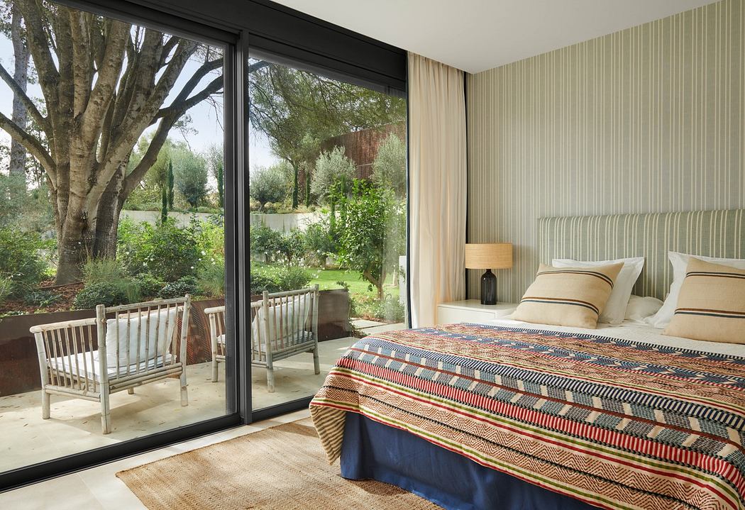 Modern bedroom with large window overlooking a garden.