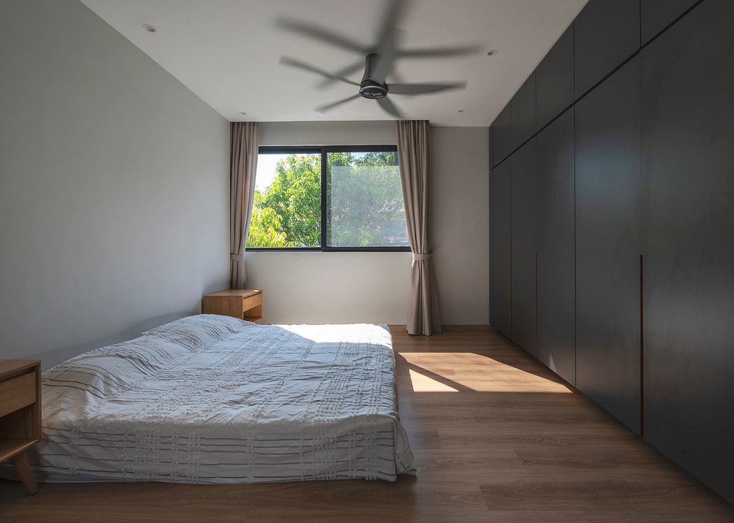 Modern minimalist bedroom with large window and wooden floor.