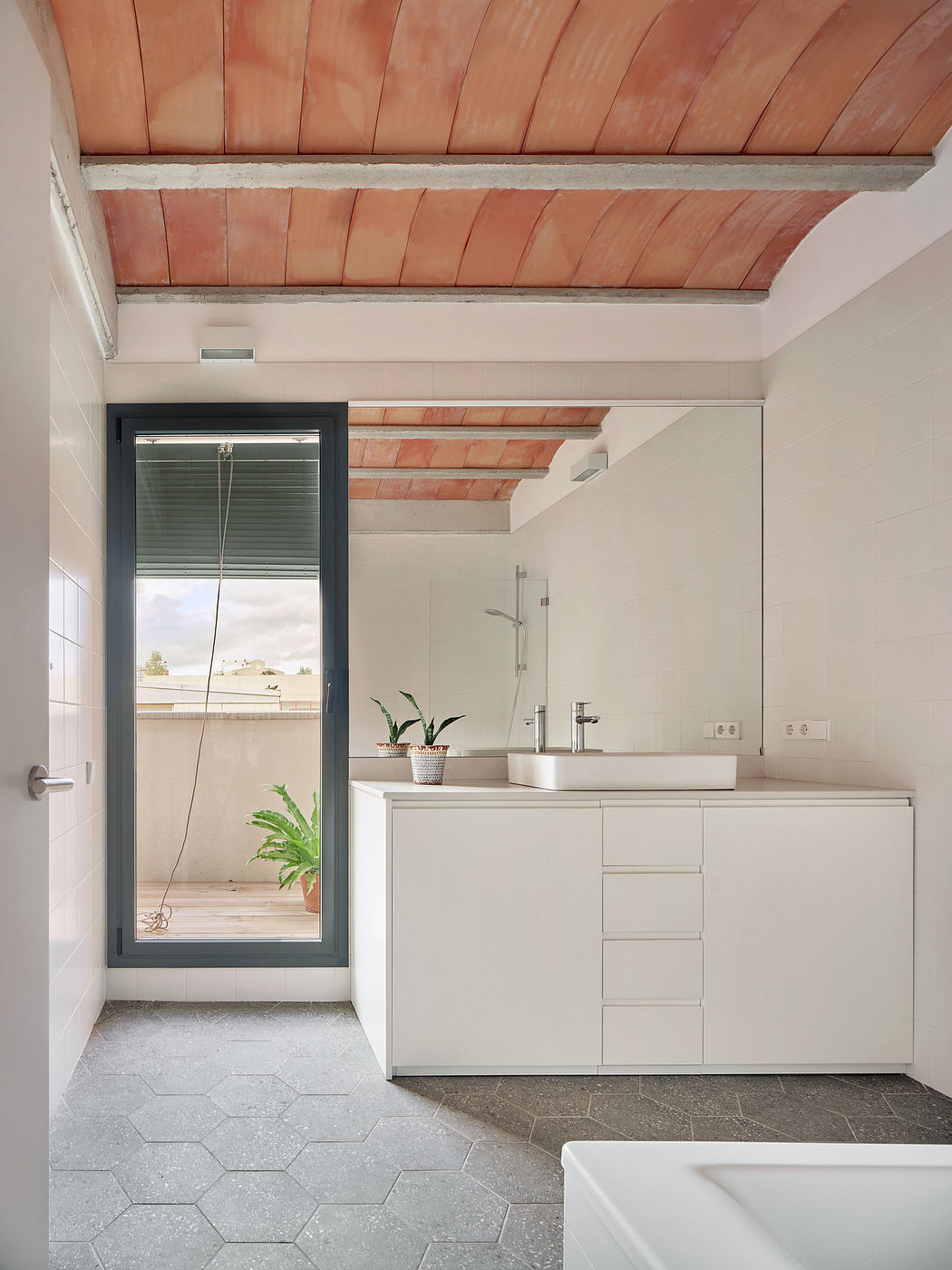 Modern bathroom with white vanity, terracotta ceiling tiles, and hexagonal floor