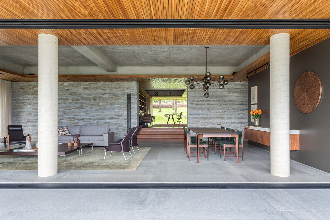 Modern open-concept living space with wooden ceiling and minimalist furniture.