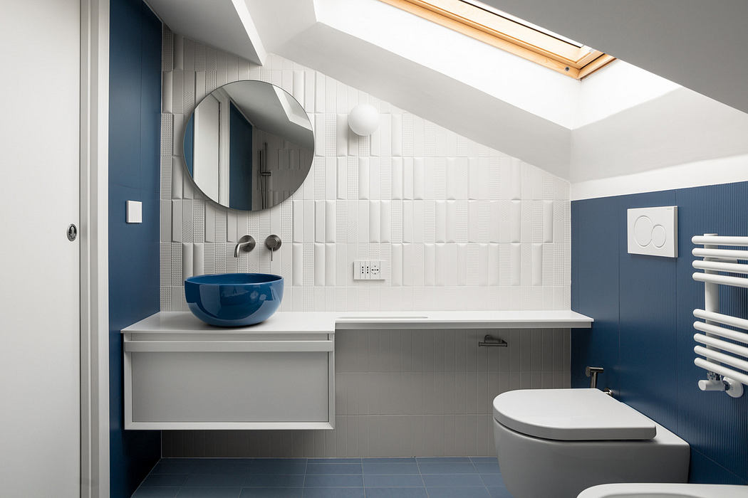 Modern bathroom with blue accents and skylight.