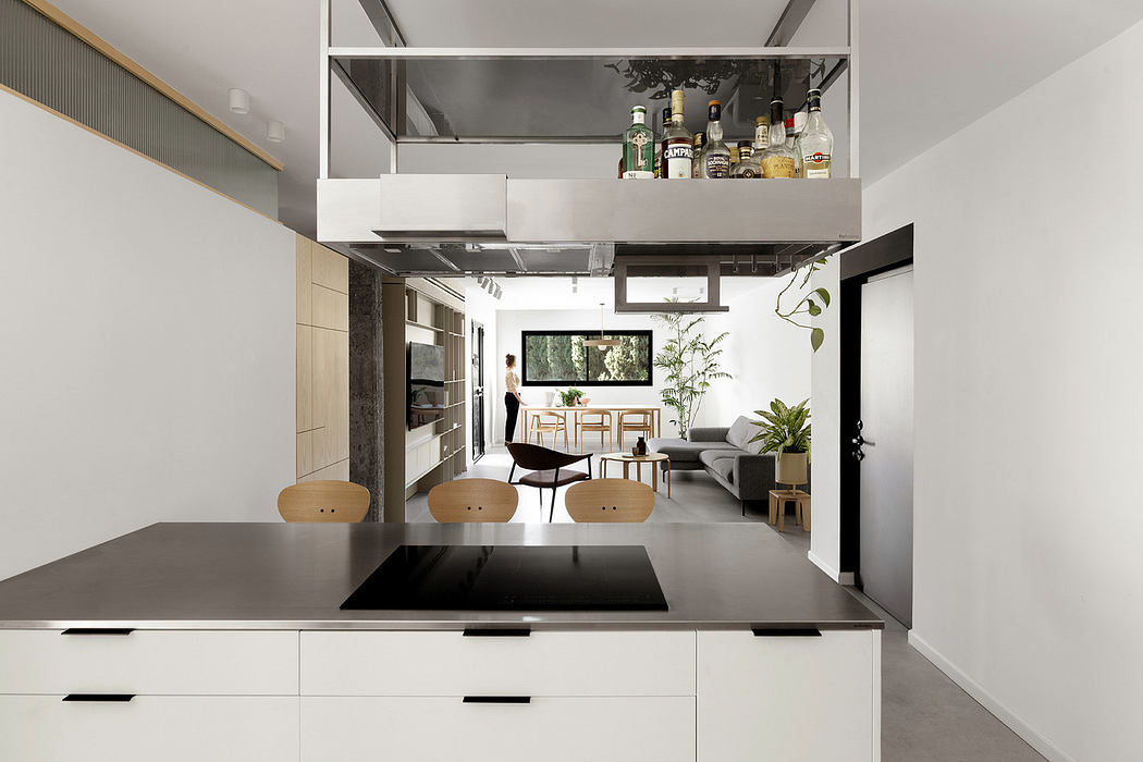 Modern kitchen interior with clean lines and open-plan living space in the background.