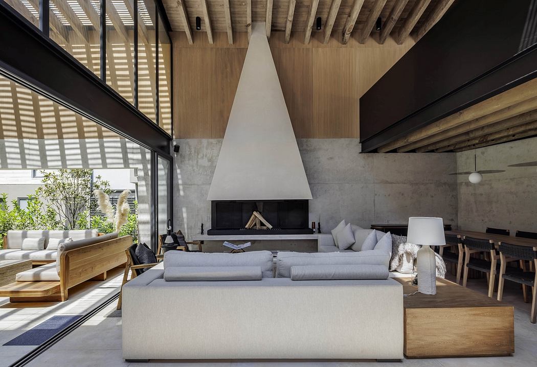 Modern living room with a pyramid-style fireplace, wooden ceiling, and minimalist furniture.
