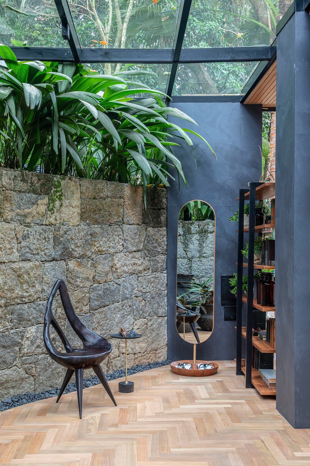 Modern interior with glass ceiling, stone wall, and wooden floor.