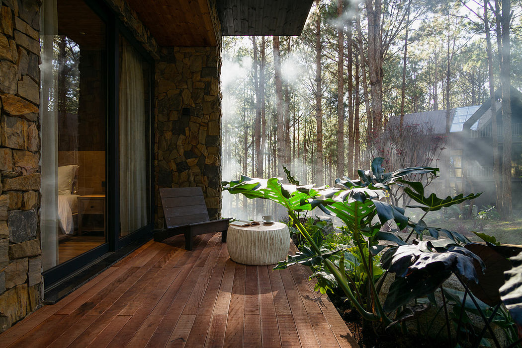 Sunlit wooden porch with stone walls, plants, and forest view.