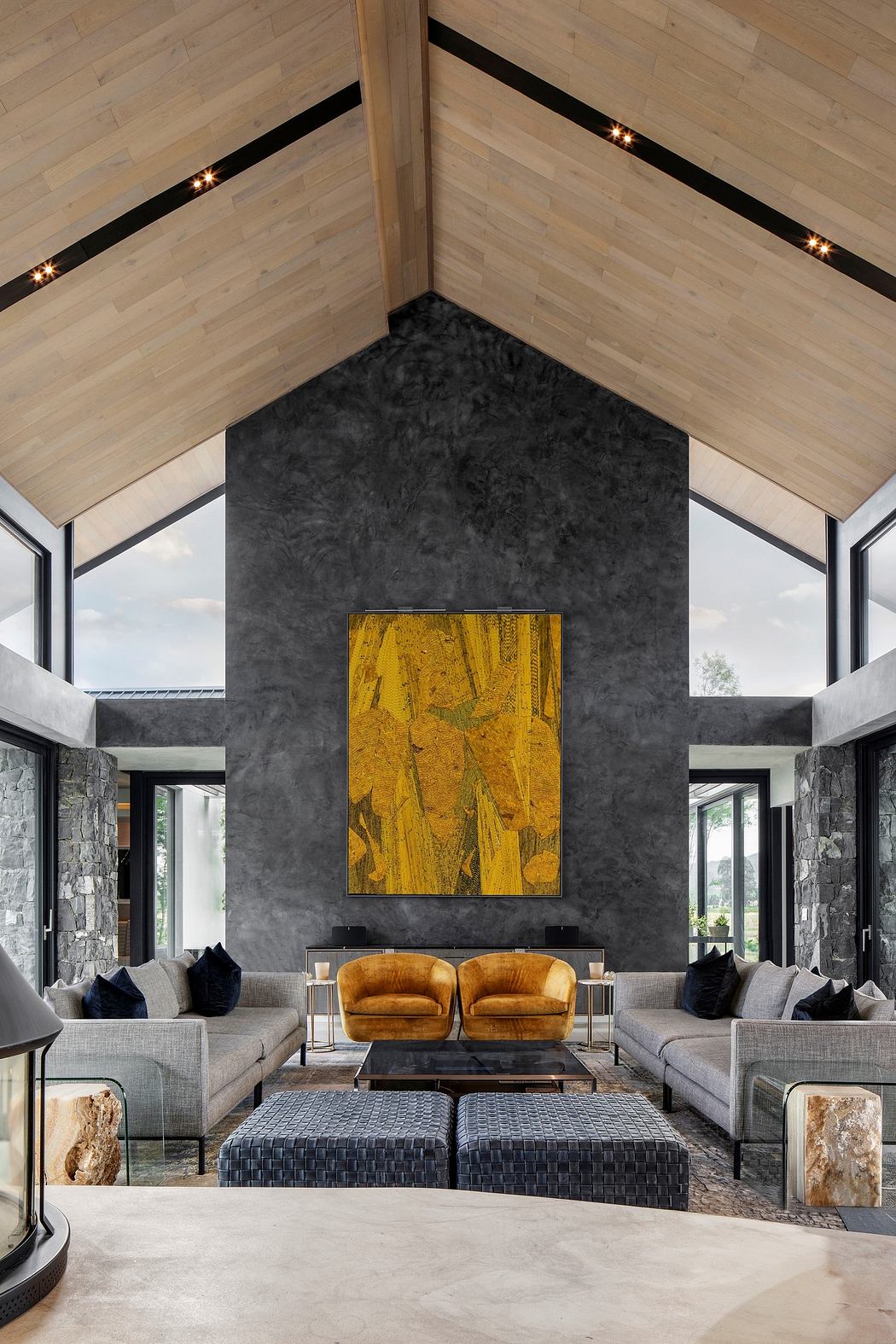 Modern living room with high ceilings, gray walls, and a bold art piece.