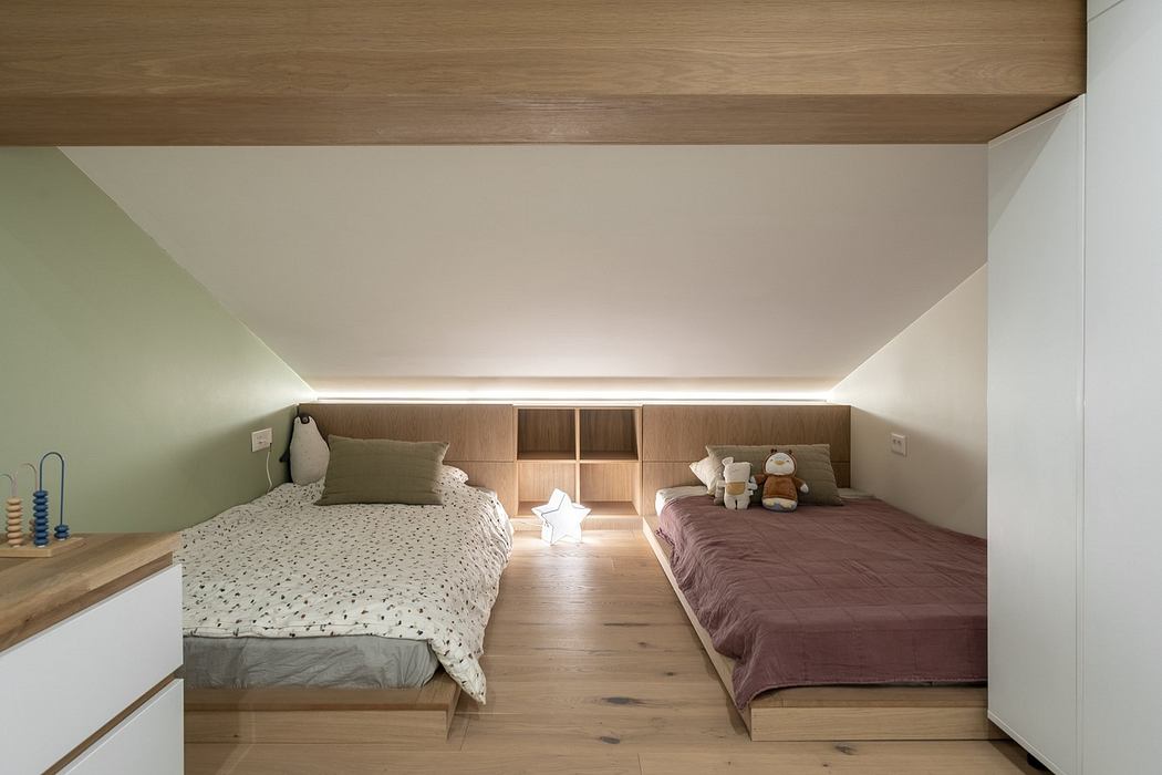 Minimalist bedroom with two beds, wooden floors, and built-in shelves.
