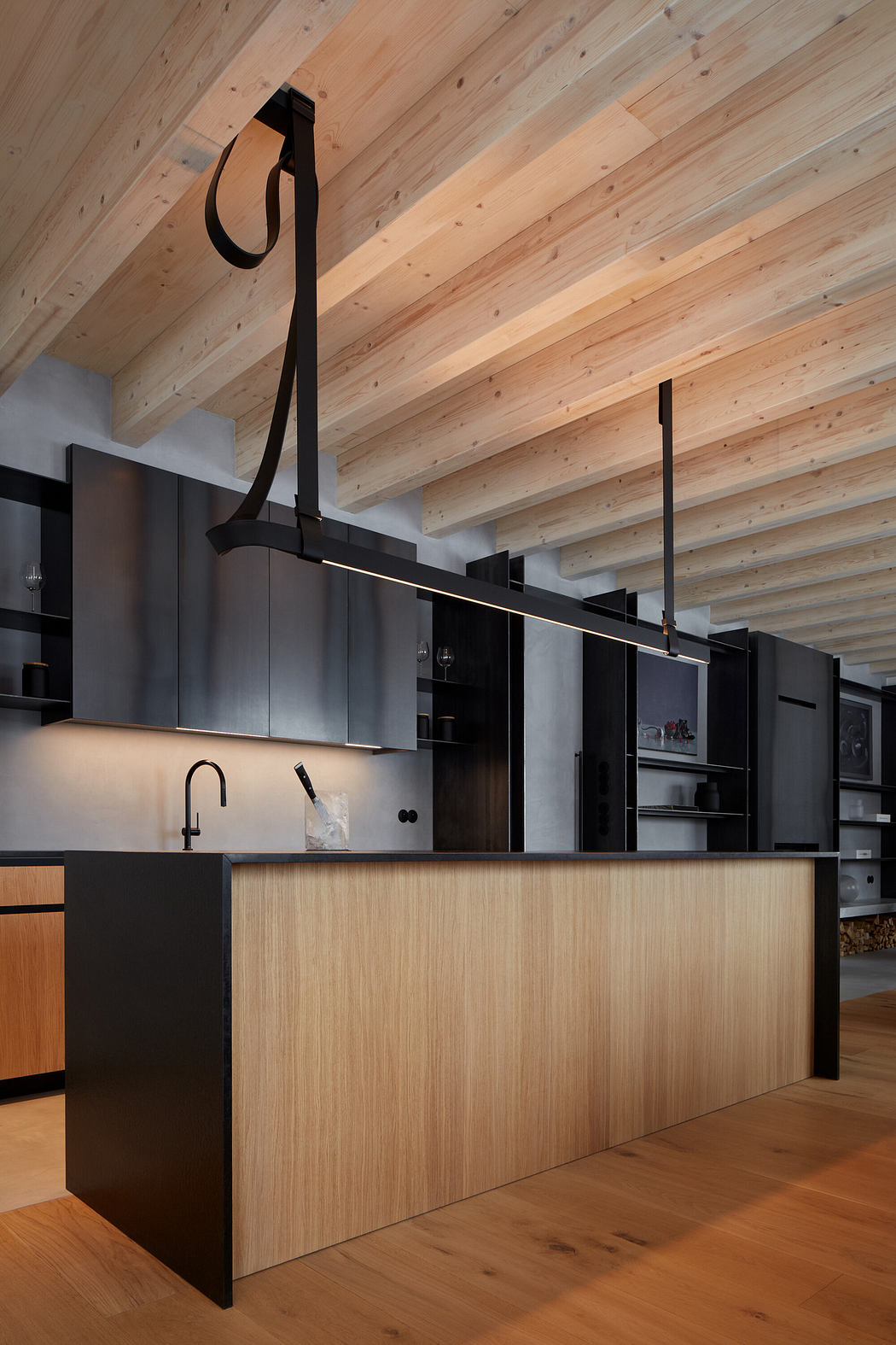 Modern kitchen with wooden ceiling and contrasting black cabinets.