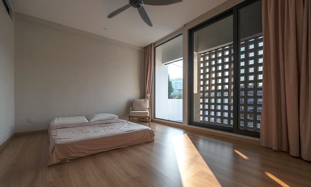 Minimalist bedroom with large window, wooden floor, and ceiling fan.