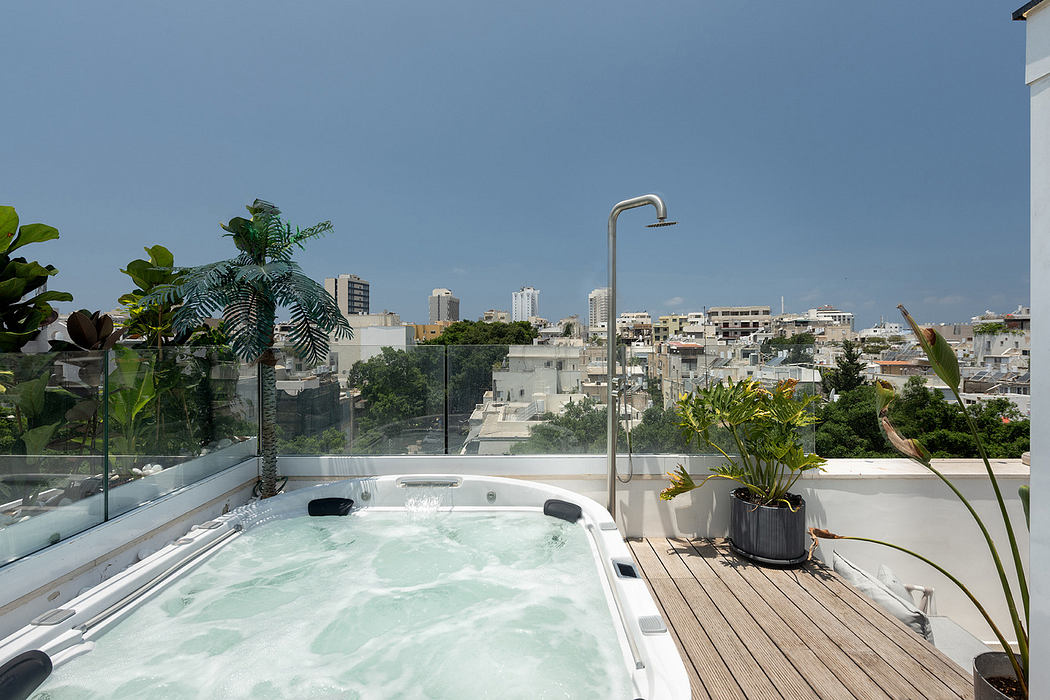 Rooftop hot tub with cityscape view and surrounding greenery.