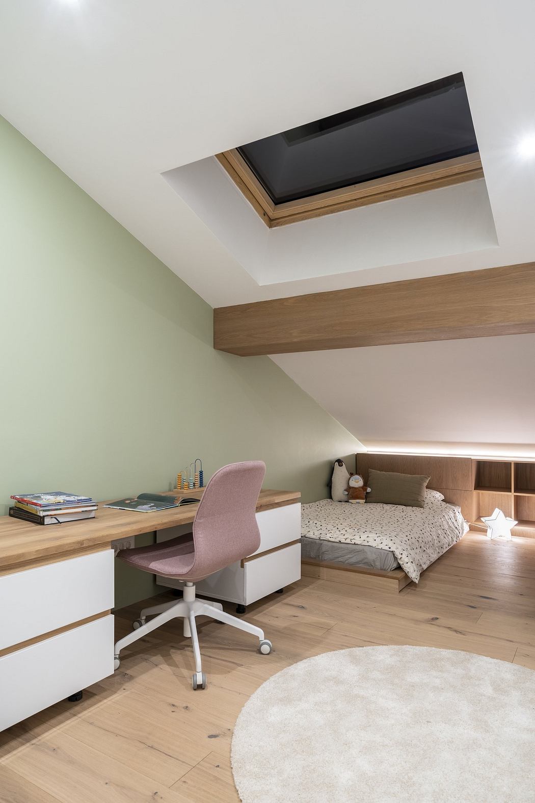 Modern attic home office and bedroom with skylight.