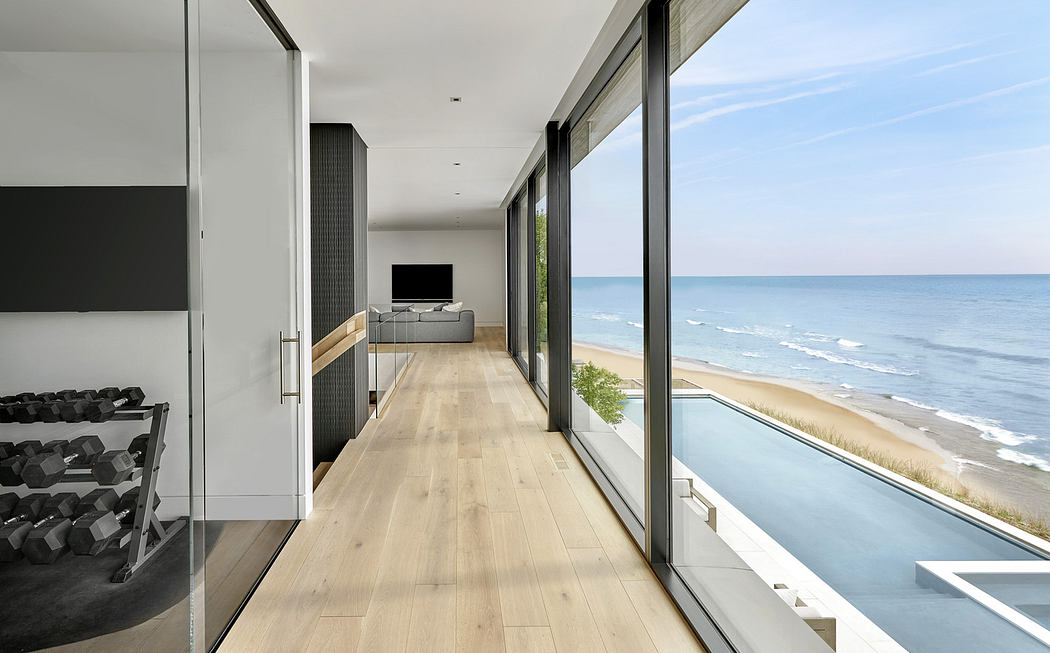 Modern hallway with large windows overlooking a beach.
