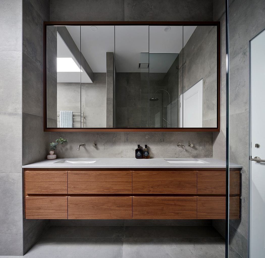 Modern bathroom with a large mirror and floating wooden vanity.